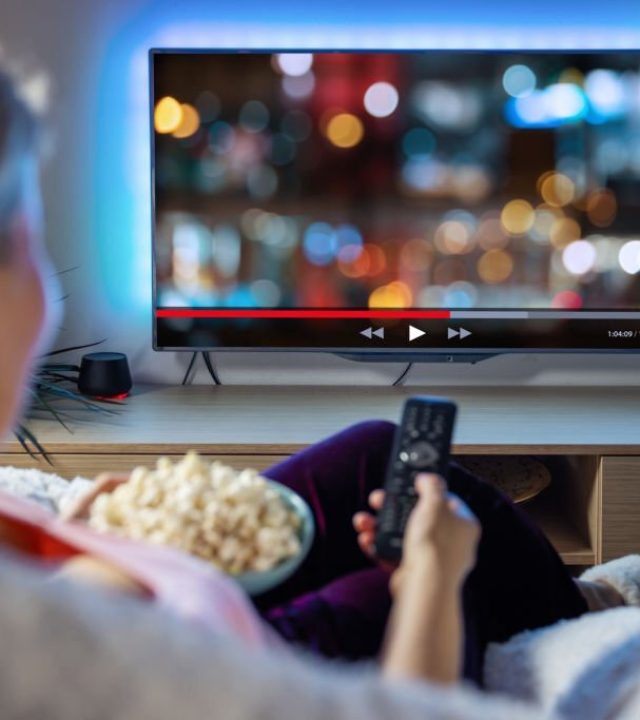 Female relaxing at home in evening and watching TV Female relaxing at home in evening and watching TV